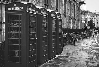 Row of vintage telephone boxes on a cobblestone street