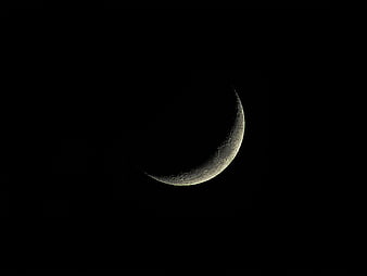 Crescent Moon with Craters Against Black Night Sky