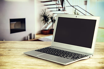 Silver laptop on wooden table in modern home office