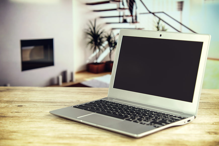 Silver laptop on wooden table in modern home office
