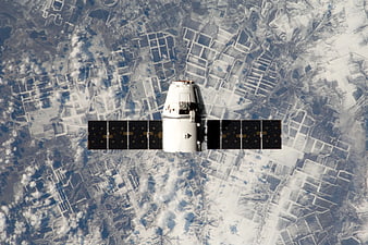 Spacecraft with solar panels orbiting snowy Earth