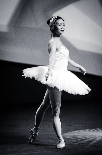 Ballerina in tutu performing on stage in black and white
