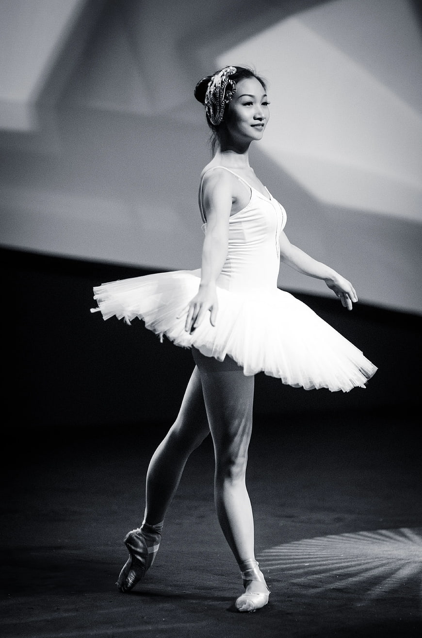Ballerina in tutu performing on stage in black and white