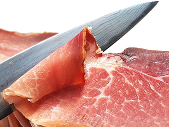 Close-up of sliced cured ham on a knife blade
