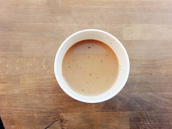 Top View of Coffee with Milk in White Cup on Wood