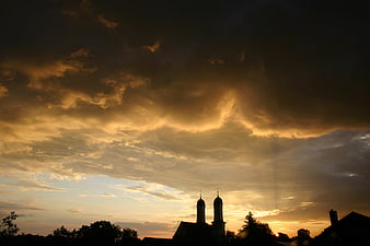 Dramatic sunset clouds over church silhouette