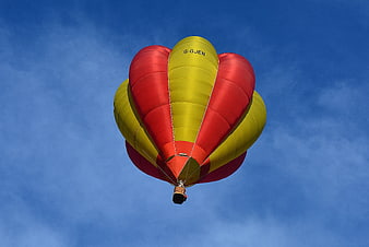 Red and Yellow Hot Air Balloon Flying in Blue Sky