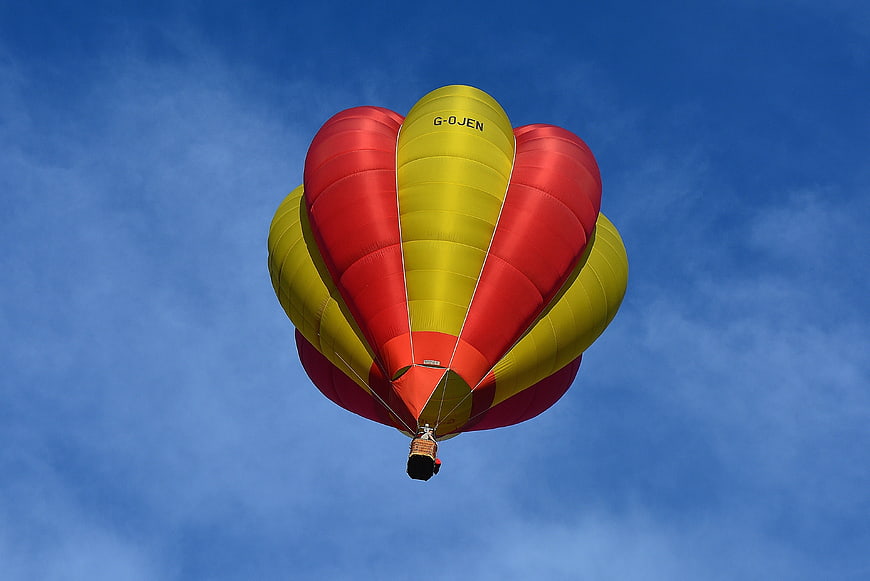 Red and Yellow Hot Air Balloon Flying in Blue Sky