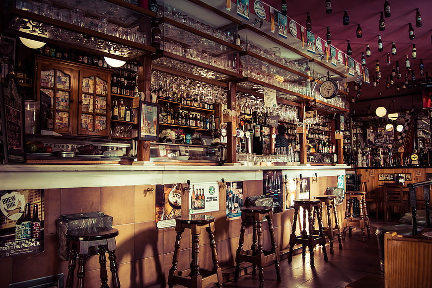 Empty Traditional Pub Interior with Wooden Bar and Stools