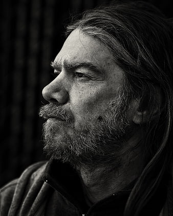 Black and white profile portrait of a bearded man with long hair