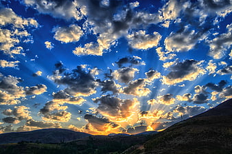 Dramatic Sun Rays Breaking Through Clouds Over Mountain Plateau