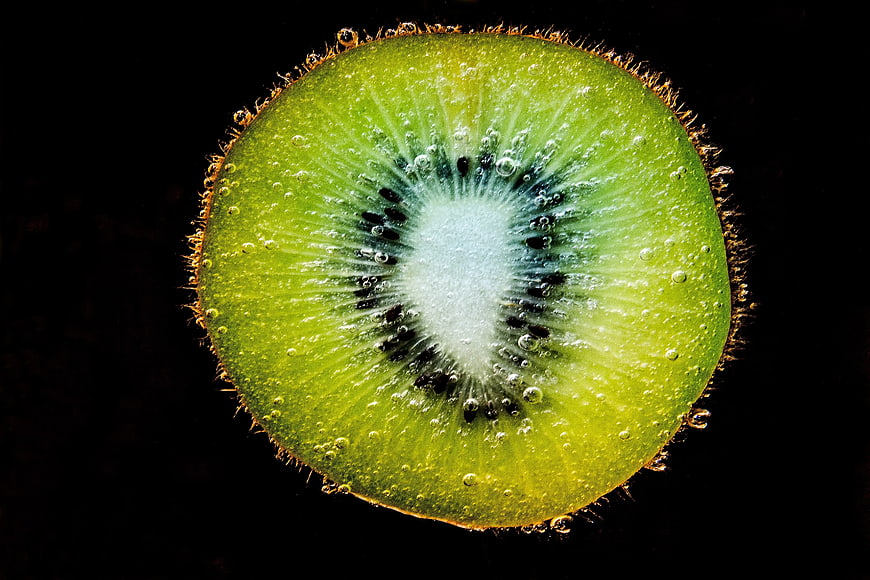 Sliced Kiwi Fruit in Sparkling Water on Black Background