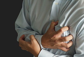 Close-up of man clutching chest in white shirt