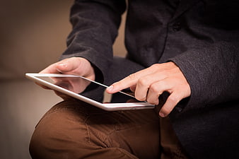 Close-up of hands using a white tablet computer