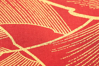 Close-up of red fabric with gold geometric pattern texture