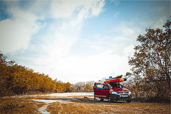Red SUV with Kayak on Roof in Snowy Forest