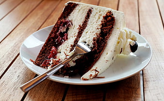 Slice of Black Forest Cake with Cream and Cherries on Wooden Table