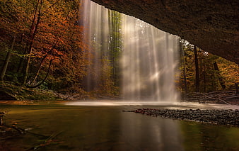 Sunbeams Illuminating Waterfall In Autumn Forest
