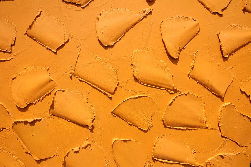 Textured orange paint wall with thick impasto strokes