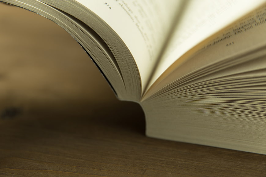 Close-up of Open Book Pages on Wooden Table