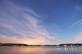 Panoramic Night Sky Over Calm Lake with Star Trails