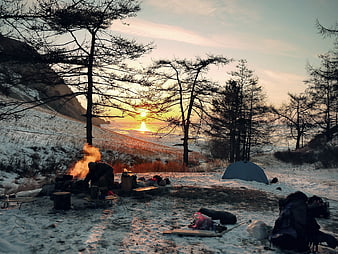 Winter Camping Scene With Campfire And Tent At Sunset