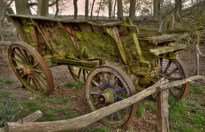 Weathered antique wooden farm cart in rustic countryside