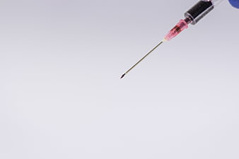 Close-up of a medical syringe needle against a clean white background