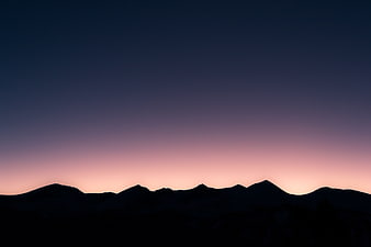 Silhouette of mountain range against twilight gradient sky