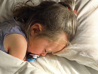 Sleeping Toddler Girl with Pacifier in Bed