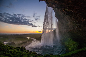 View from behind a waterfall at sunset in Iceland