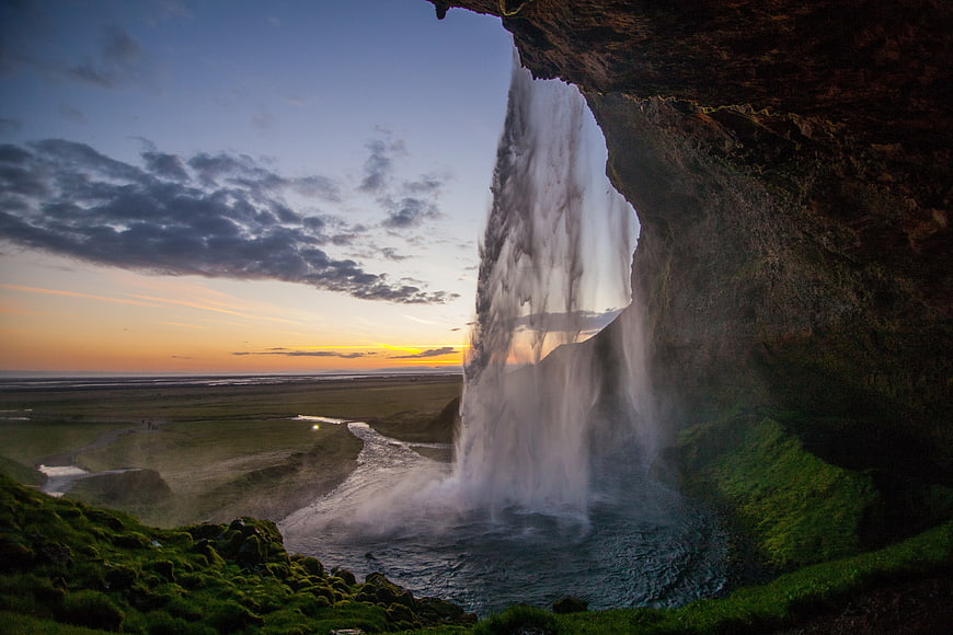 View from behind a waterfall at sunset in Iceland