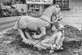 Black and white photo of stone horse trampling man sculpture