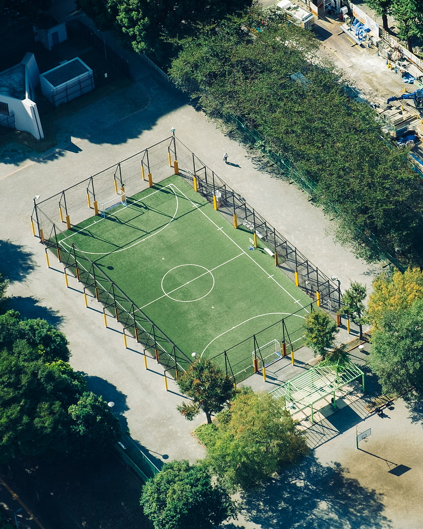 Aerial View of Green Soccer Field Surrounded by Trees