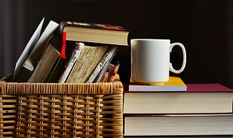 Cozy Study Scene With Wicker Basket Of Books And White Coffee Mug