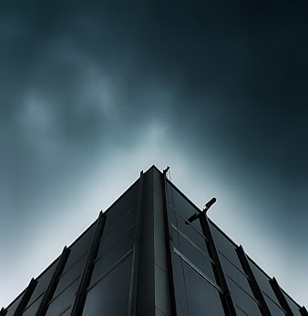 Low angle view of modern building corner against dark sky