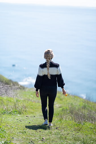 Woman Walking on Coastal Cliff Path