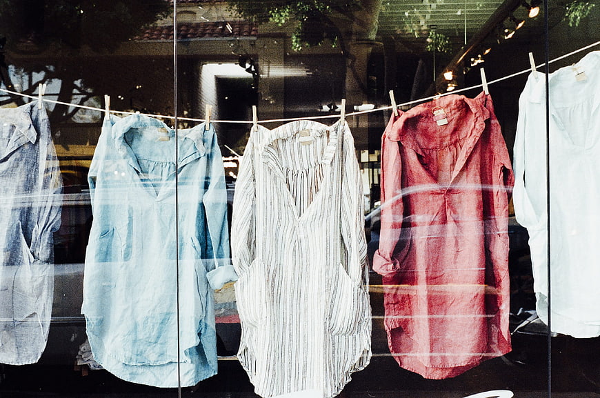 Colorful shirts hanging on a clothesline in a shop window