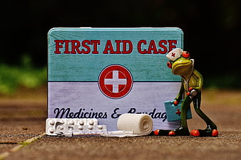 Cute frog doctor figurine with first aid kit and medical supplies