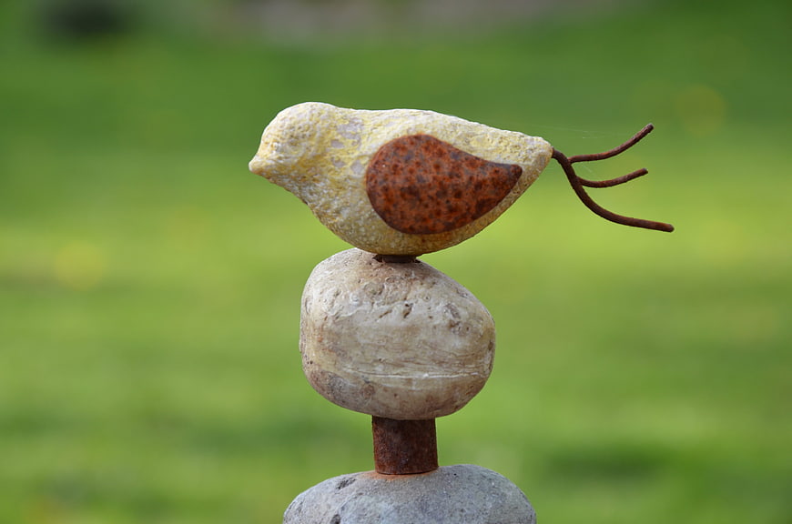 Handcrafted stone bird sculpture in a garden
