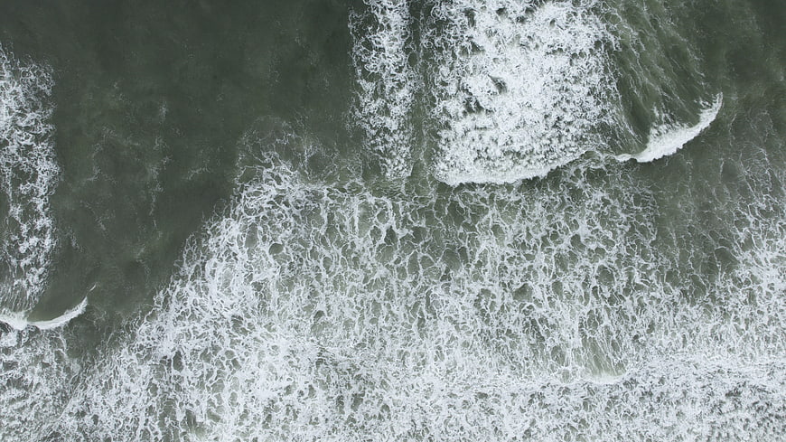 Aerial View of Ocean Waves and Sea Foam Texture