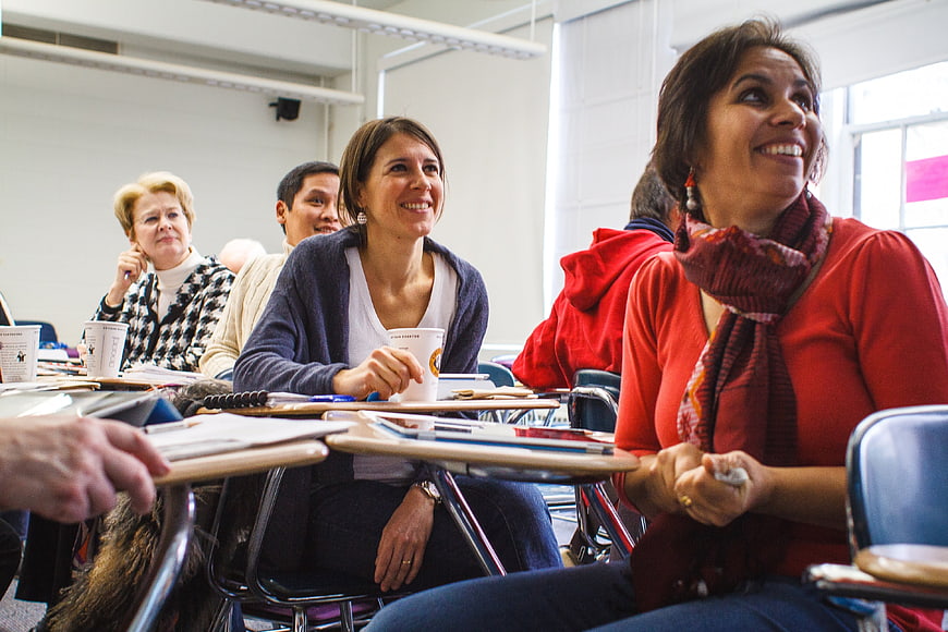 Diverse Group Of Women Attending Professional Workshop In Classroom
