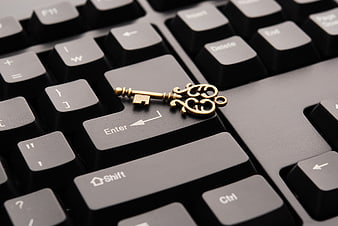 Vintage brass key on black computer keyboard enter key