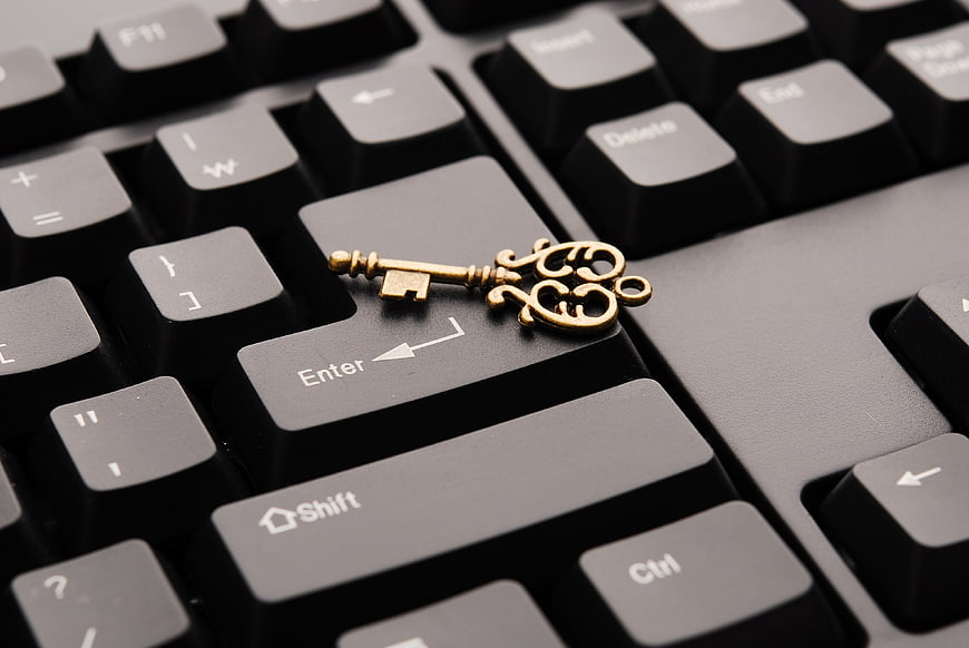Vintage brass key on black computer keyboard enter key