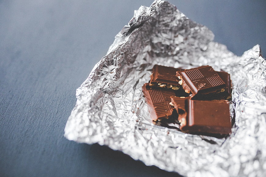 Broken chocolate pieces on crumpled aluminum foil