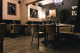 Dimly lit restaurant interior with tables and framed art