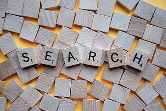 Scrabble Tiles Spelling Search on Yellow Background