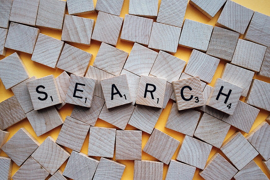 Scrabble Tiles Spelling Search on Yellow Background