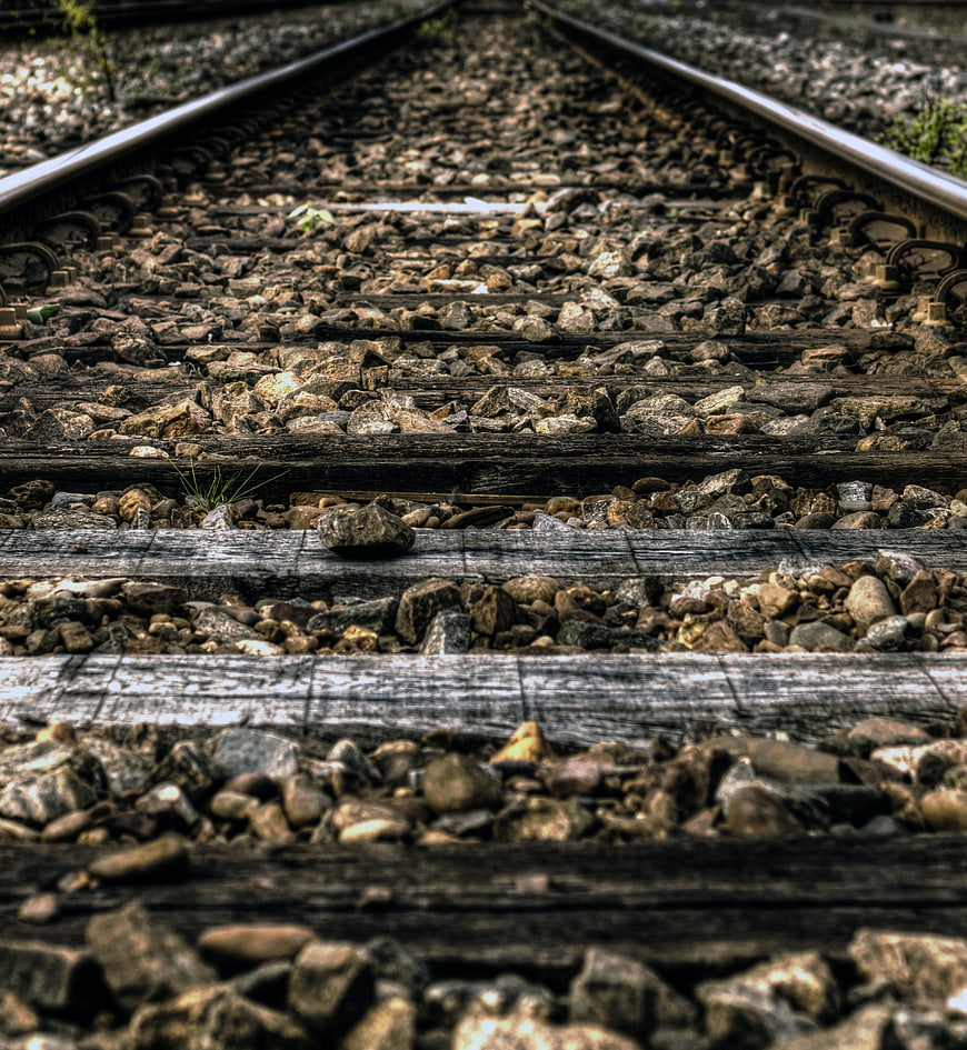 Close-up of weathered railroad tracks with gravel and wooden ties