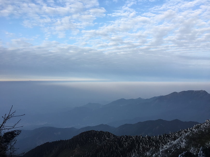 Snowy mountain peaks with layered blue ridges and cloudy sky